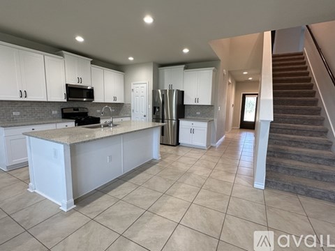 A kitchen with white cabinets and a granite countertop.