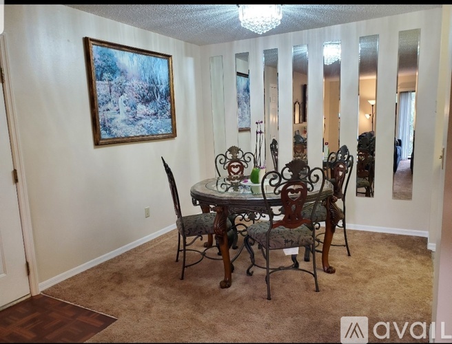 A dining room with a table and chairs.
