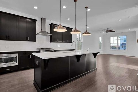 A modern kitchen with black cabinets and a large island.