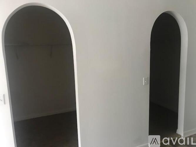 A room with two white doors and carpeted floor.