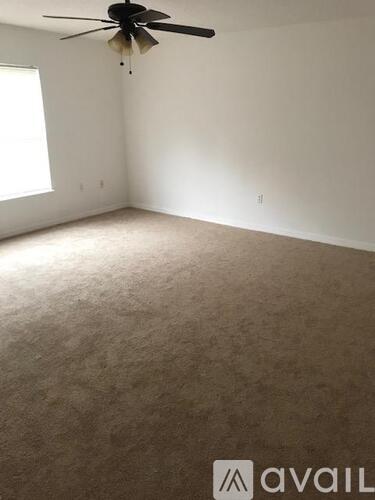 A room with wooden flooring and a ceiling fan.