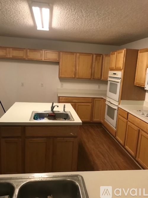 A kitchen with wooden cabinets and a white fridge.