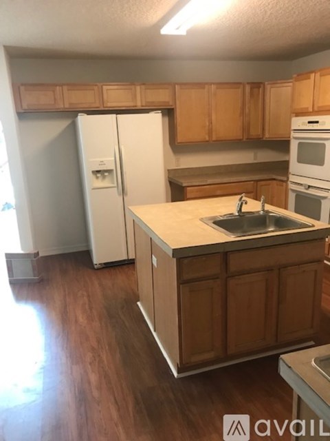 A kitchen with wooden cabinets and a white fridge.