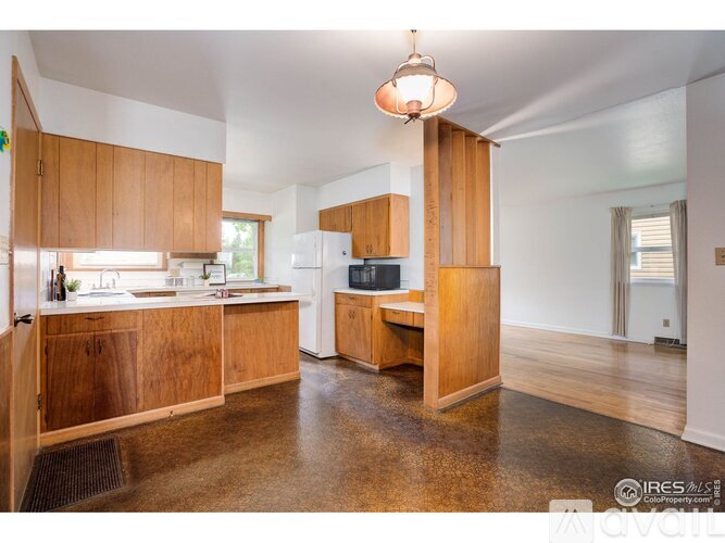 A kitchen with wooden cabinets and a white refrigerator.