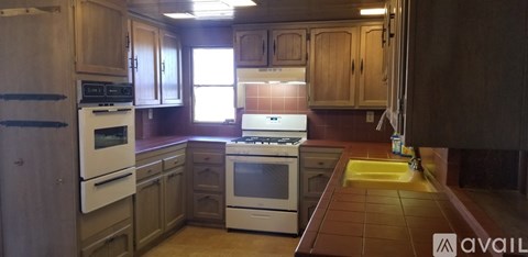 A kitchen with a white stove and white oven.