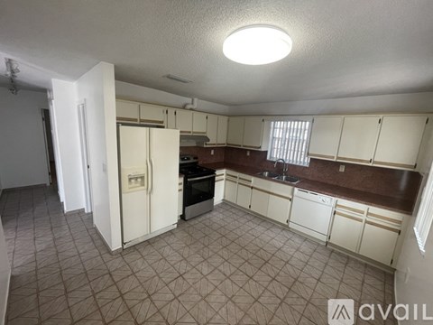 A kitchen with white cabinets and a brown countertop.