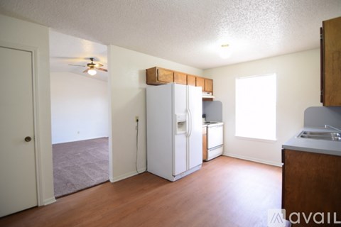 A kitchen with a white refrigerator and wooden cabinets.