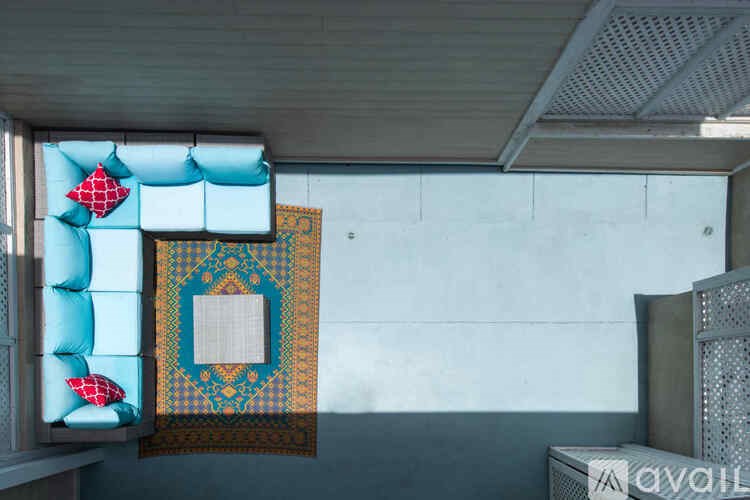 A room with a blue wall and a patterned quilt hanging on it.