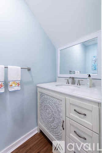A bathroom with a white counter and a white sink.