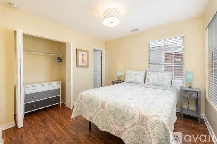 A bedroom with a bed, nightstand, and a dresser.