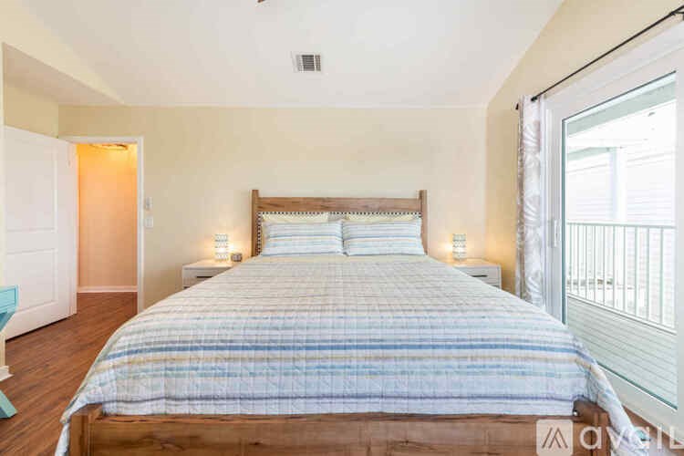 A bedroom with a bed, nightstands, and a window.