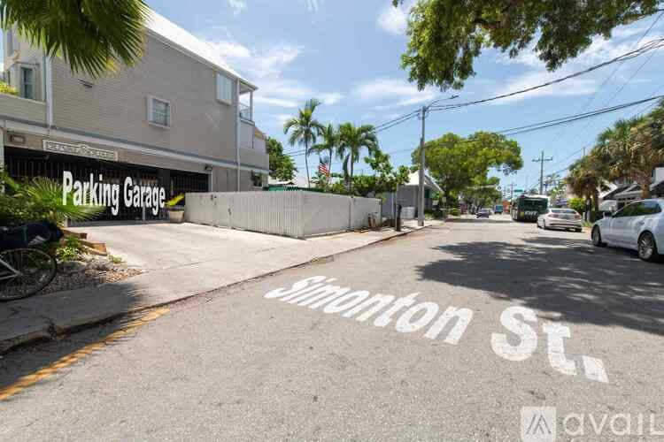 A street view with a parking garage on the left and a car parked on the right.