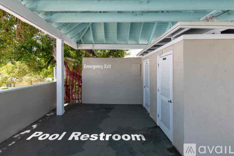 A pool restroom with an emergency exit sign.