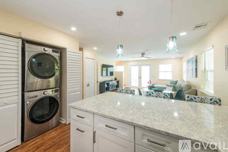 A modern kitchen with a washing machine built into the cabinetry.
