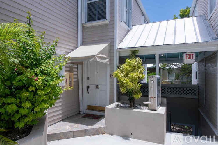 A white house with a red sign on the door.