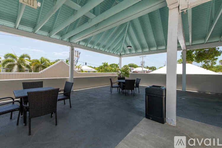 A patio with a table and chairs under a green canopy.