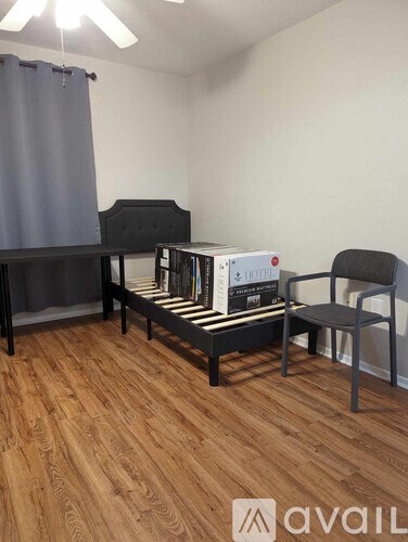 A room with a black chair, a black table, and a black shelf with a white box on it.