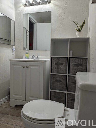 A white toilet in a bathroom with a cabinet and mirror.