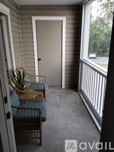 A balcony with a chair and a door.