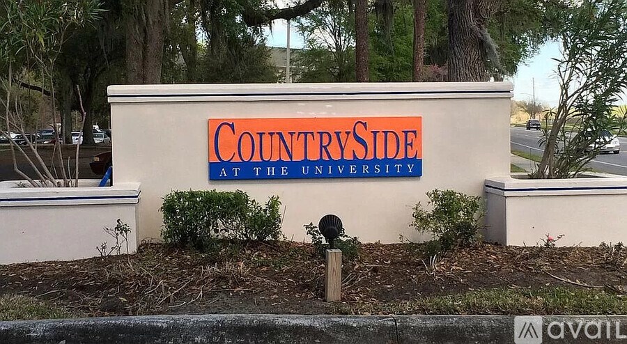 A sign that says "CountrySide at the University" is in front of some trees.