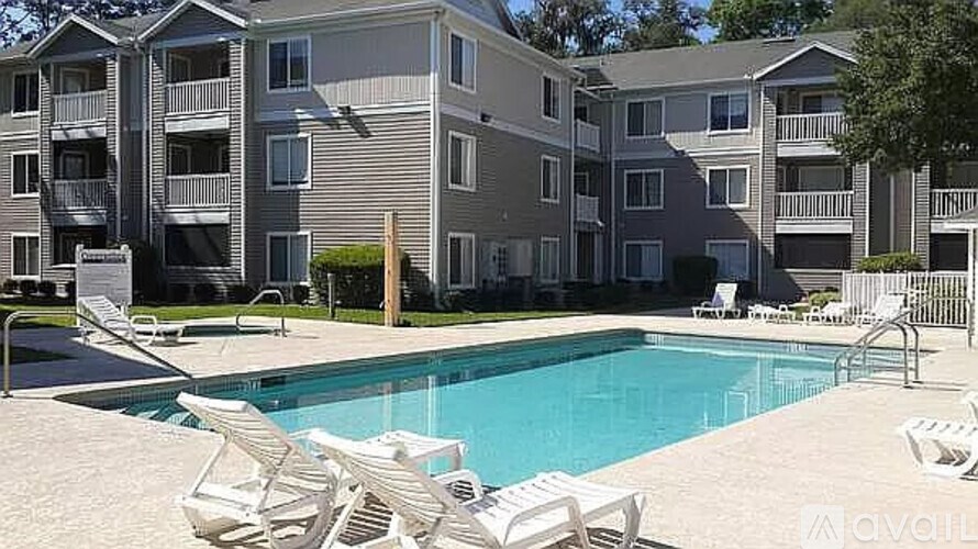 A large apartment complex with a pool in front.