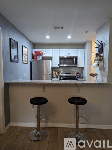 A kitchen with a bar stool in front of a counter.