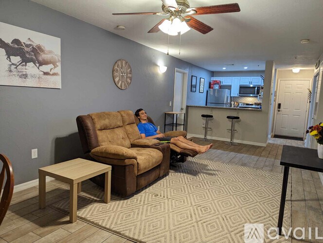 A man is sitting on a couch in a living room.