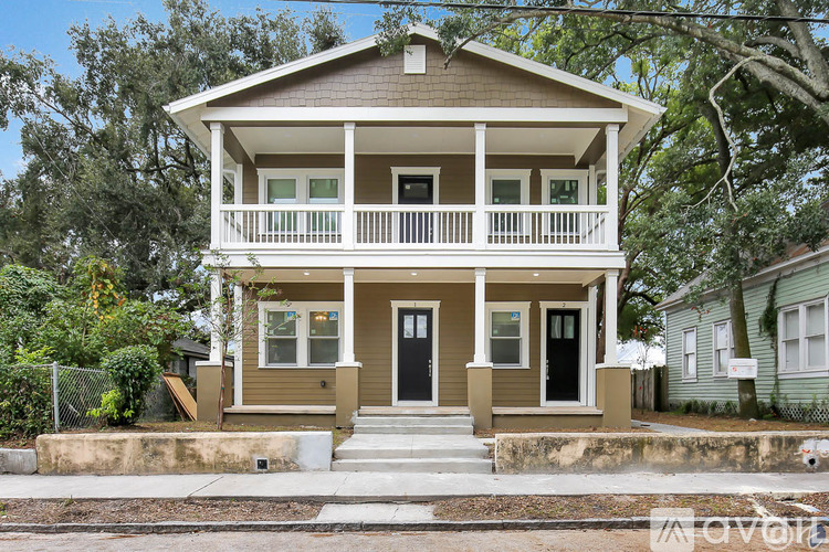 A two-story house with a front porch and a black door.
