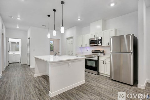 A modern kitchen with stainless steel appliances and white cabinetry.