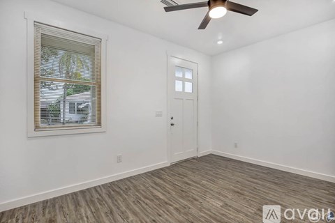 A room with a ceiling fan and a door.