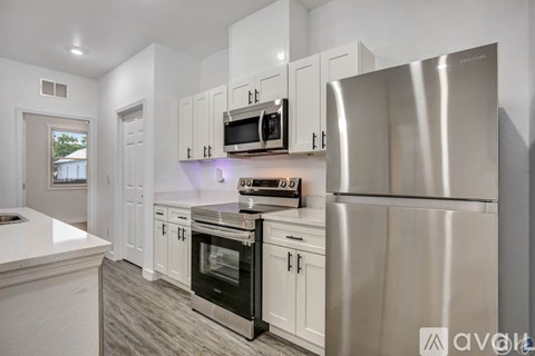 A modern kitchen with stainless steel appliances and white cabinets.