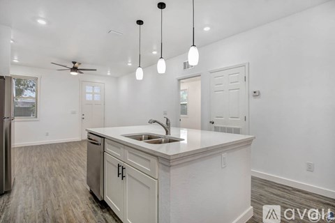 A kitchen with white cabinets and a sink under a window.