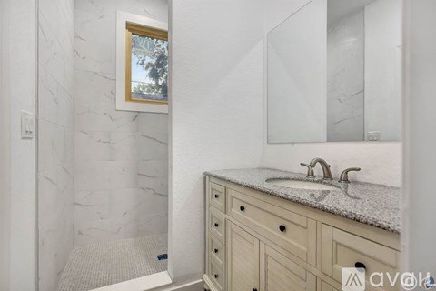 A bathroom with a marble wall and a white sink.
