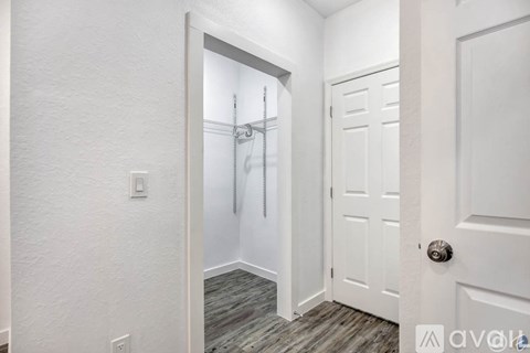 A white door is open to a bathroom with a walk-in shower.