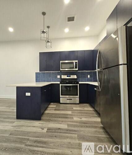 A kitchen with a blue cabinet and a stainless steel refrigerator.