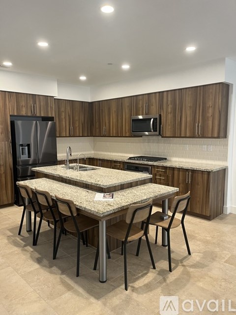 A kitchen with a table and chairs and a fridge.