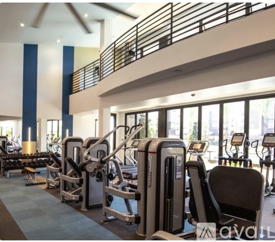 A gym with a variety of equipment including treadmills, weights, and exercise machines.