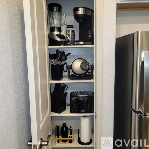 A kitchen pantry with a refrigerator on the right.