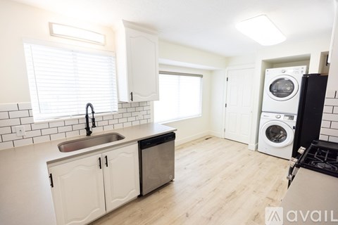 A kitchen with white cabinets and a black dishwasher.