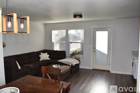 A living room with a brown couch and a wooden coffee table.