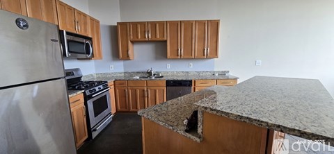 A kitchen with wooden cabinets and granite countertops.