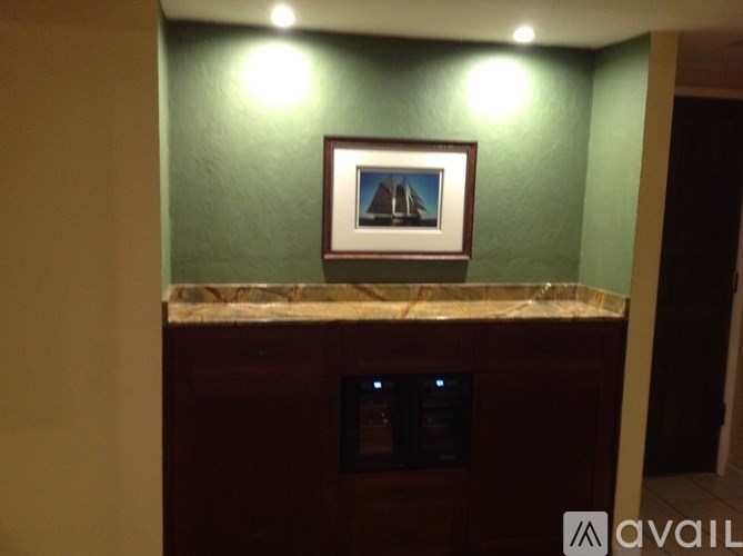 A picture of a lighthouse is hanging on a wall above a counter.