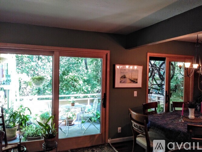 A dining room with a table set for four and a view of a backyard.