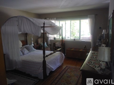 A bedroom with a four poster bed and a window.