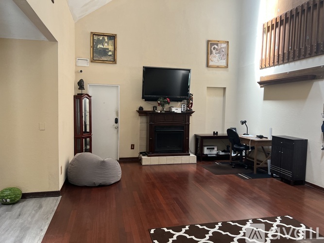 A living room with a fireplace and a television on a stand.