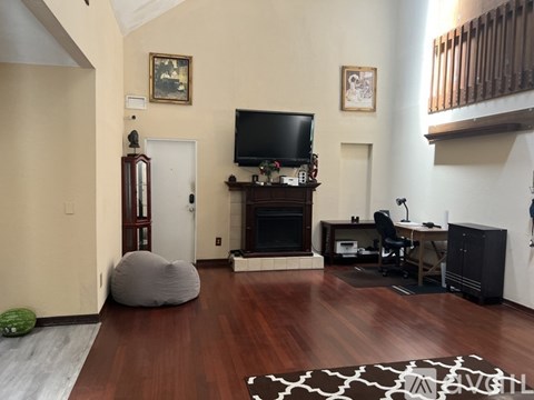 A living room with a fireplace and a television on a stand.