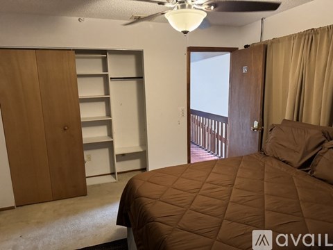 A bedroom with a brown bed and a brown wardrobe.