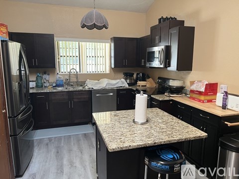 A kitchen with a granite countertop and a refrigerator.