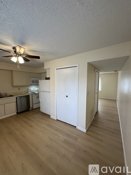 A kitchen with a refrigerator, microwave, and oven.