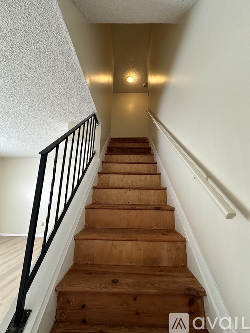 A staircase with wooden steps and black railings.